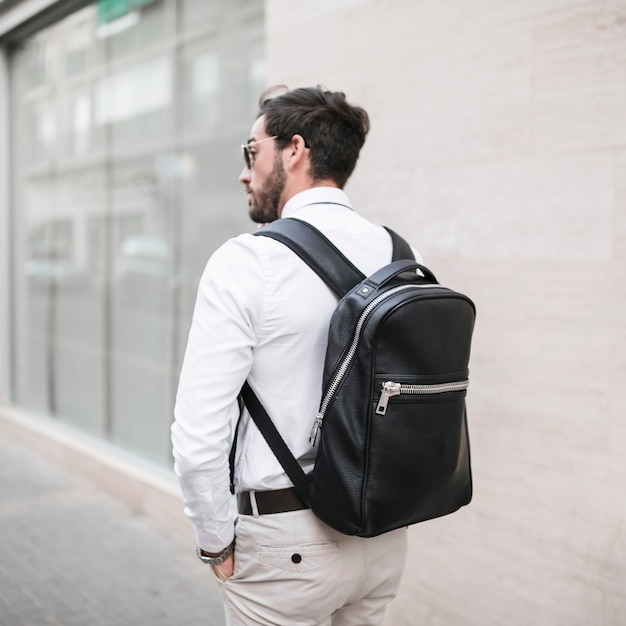 Free Photo rear view of a male tourist with black backpack