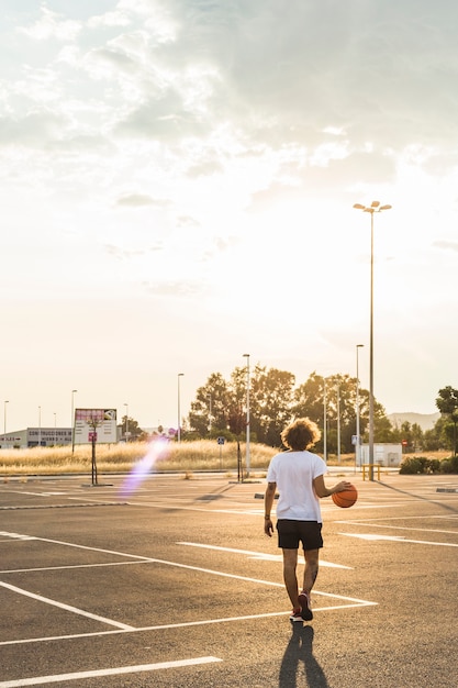 Rear view of a man playing basketball in court