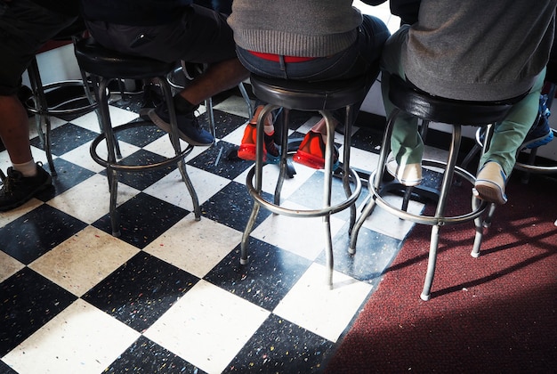 Free Photo rear view of people sitting on bar stool