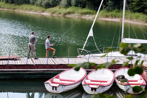 Free photo rear view of son and father fishing