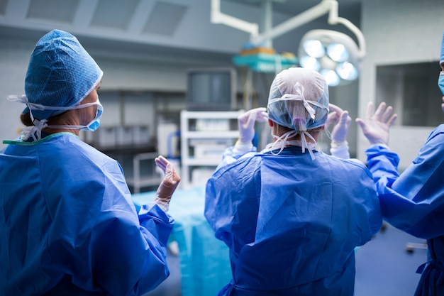 Rear view of surgeons preparing for operation in operation room