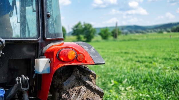 Free photo rear view of a tractor with green field on the background