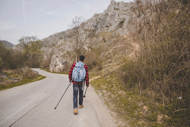 Free photo rear view of traveler walking down the road