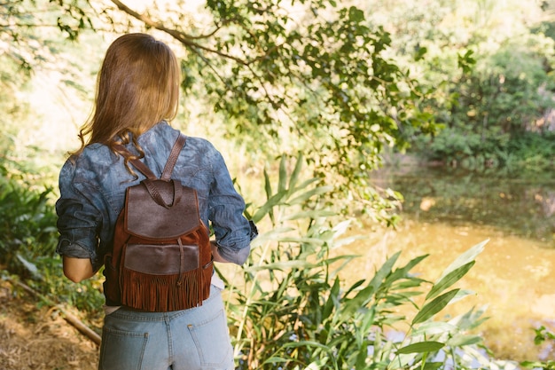 Rear view of a woman standing in forest