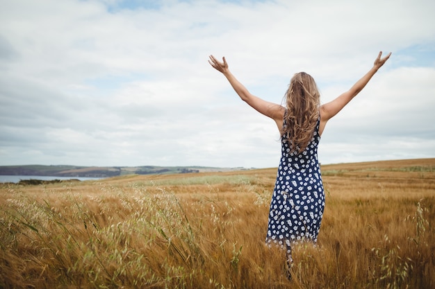 Free photo rear view woman standing with arms outstretched