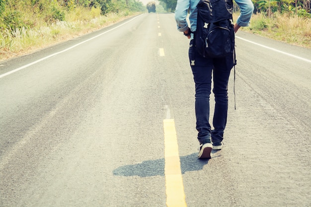 Free photo rear view of woman walking along the road