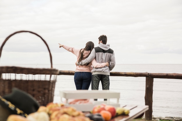 Free photo rear view of young couple overlooking the sea