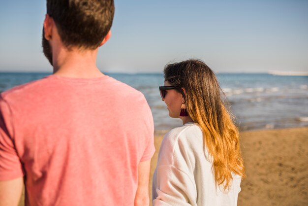 Rear view of a young couple walking at beach