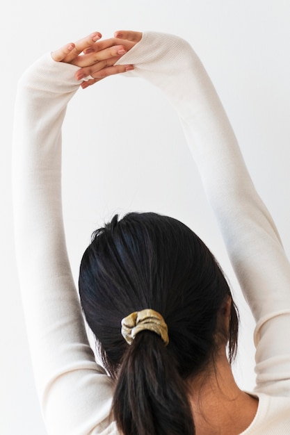 Free photo rear view of a young woman stretching her arms