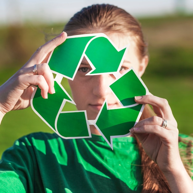 Free Photo recycle background with woman holding recycle sign