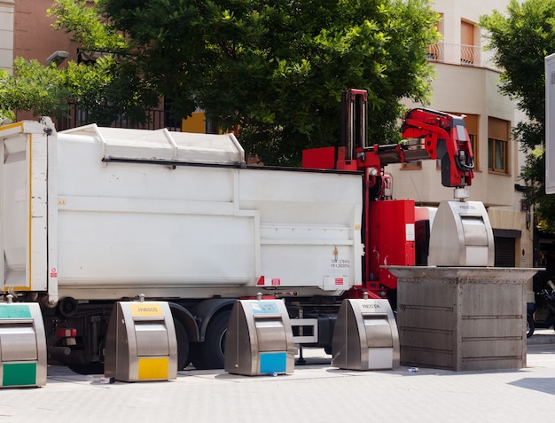 Free photo recycling truck picking up bin at city