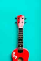 Free photo red acoustic classic guitar on turquoise background