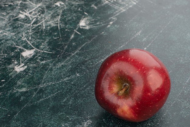 Free photo red apple on marble wall .