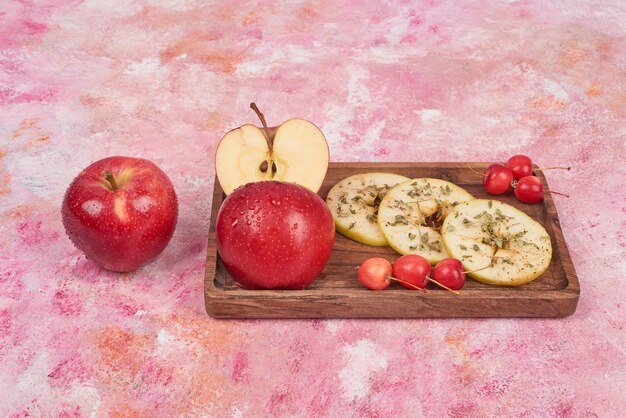 Red apples in a wooden board .