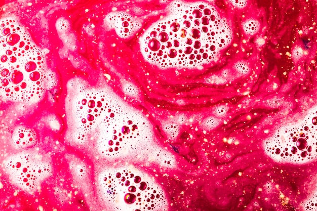 Free photo red bath bomb dissolve surface with bubbles