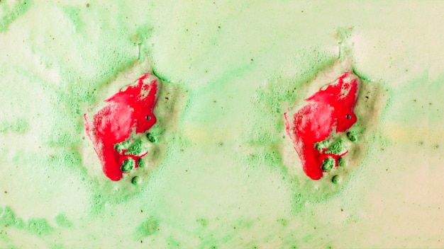 Free Photo red bathbomb dissolve in green bubble bath water