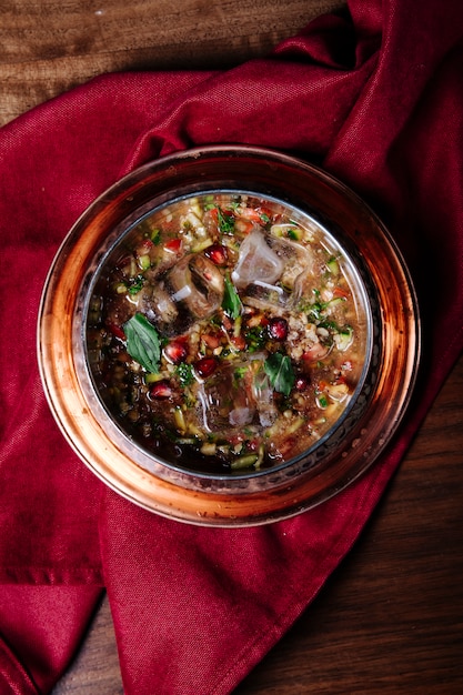 Red beans soup with herbs and spices in a copper plate.