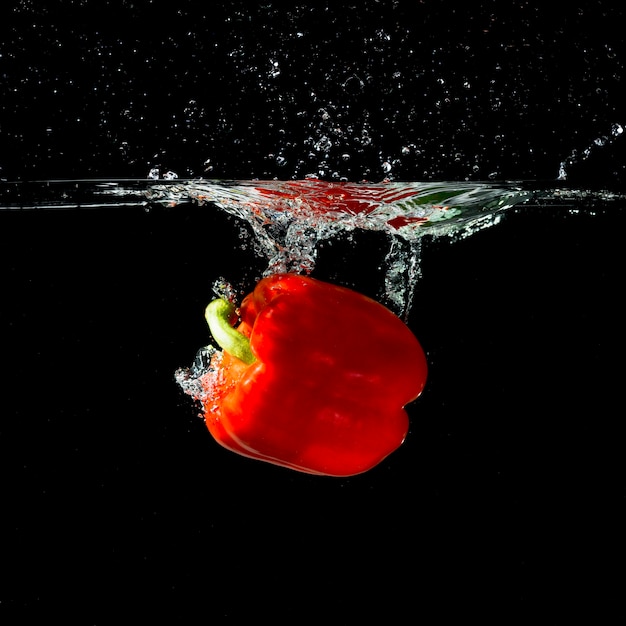 Free photo red bell pepper splash into clear water