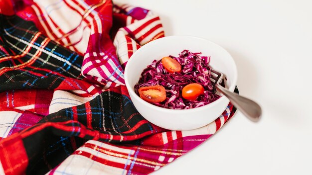 Red cabbage and tomatoes in bowl on table