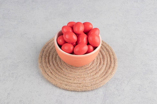 Free Photo red candies in the cup on the trivet on the marble surface