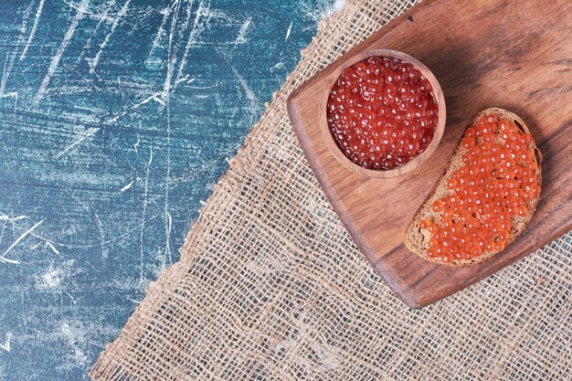 Free Photo red caviar on wooden board.