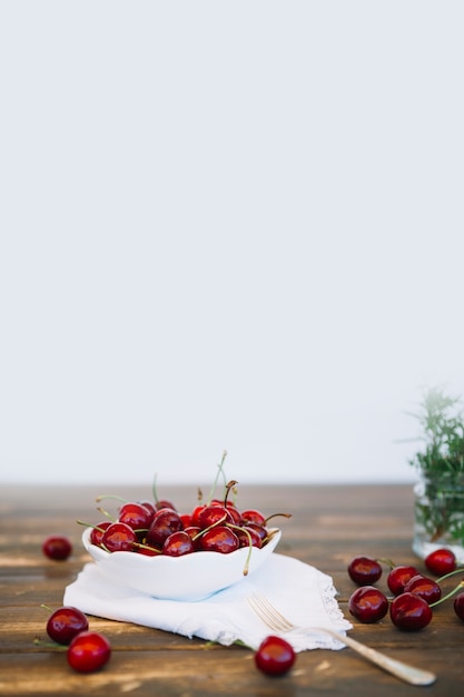 Free Photo red cherries in bowl on wooden table top