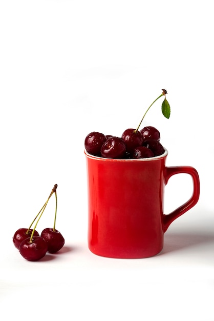 Red cherries in a cup isolated