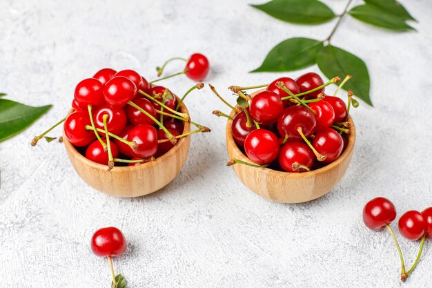 Red cherries in plate bowl on gray table