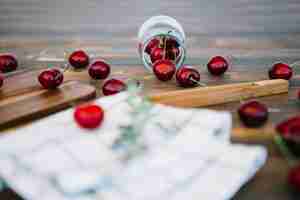 Free photo red cherries spilling out from jar