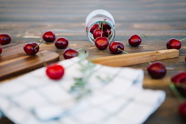 Free Photo red cherries spilling out from jar