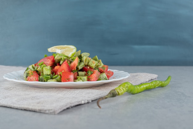 Red cherry tomato and beans salad in a ceramic plate