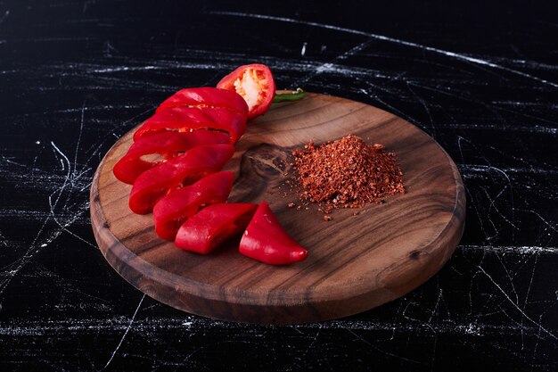 Red chili pepper and paprika on a wooden board.