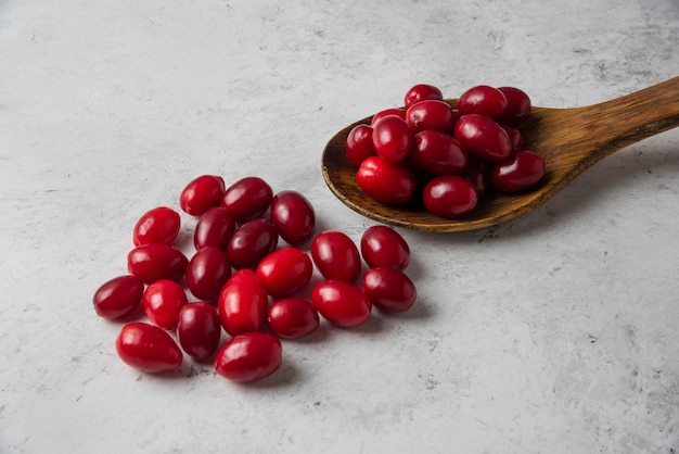 Red cornels in a wooden spoon. 