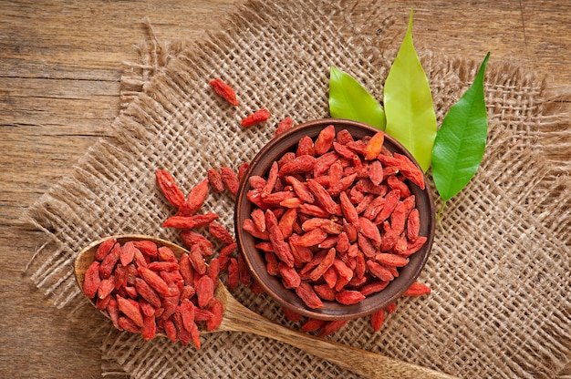 Red dried goji berries in wooden spoon