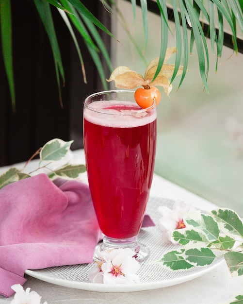 Red drink with foam and flower berry.