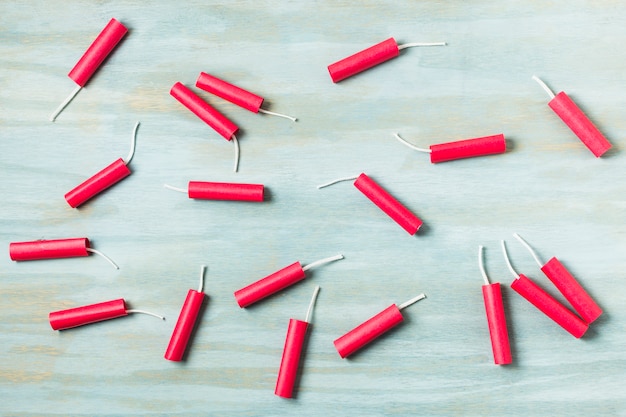 Red dynamite firecrackers on blue wooden textured background