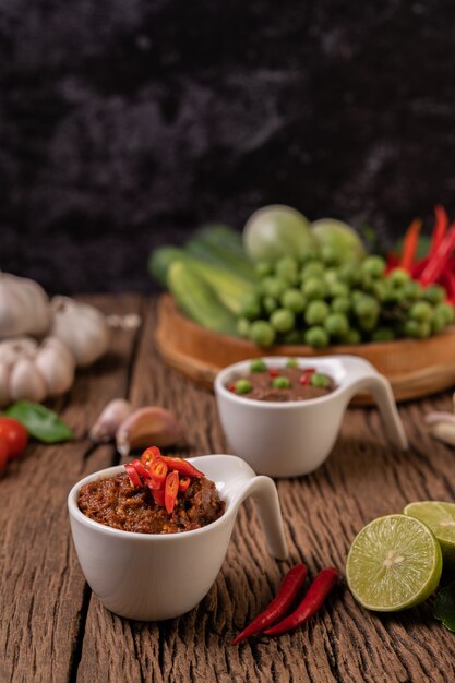 Red Eye Chili Paste with Lemon and Chili on Wooden Floor.