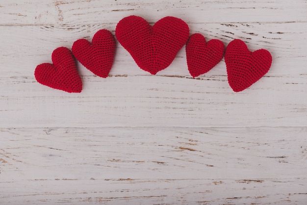 Free Photo red fabric hearts on a wooden table