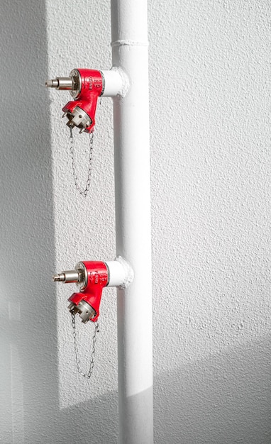 Free Photo red fire extinguisher on white wall