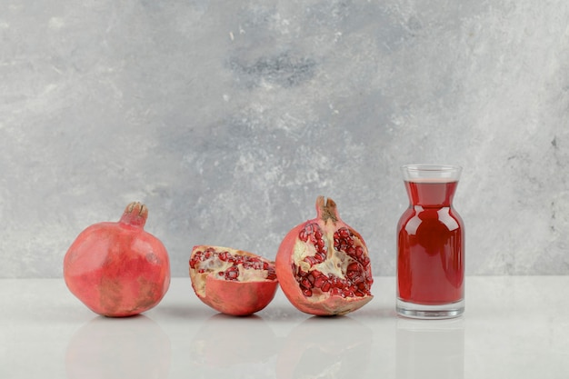 Free photo red fresh pomegranates and fresh juice on white table.