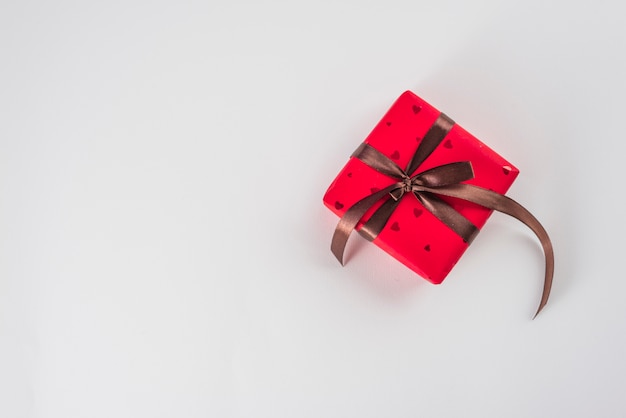 Free Photo red gift box with brown ribbon