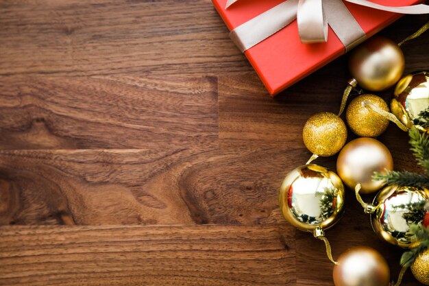 Red gifts and yellow christmas balls on wooden table