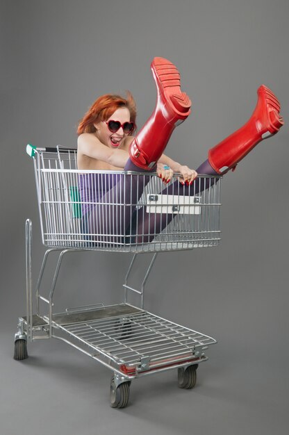 Red girl riding on a shopping cart