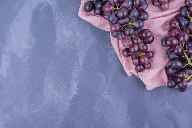 Red grape bunches on piece of pink towel.