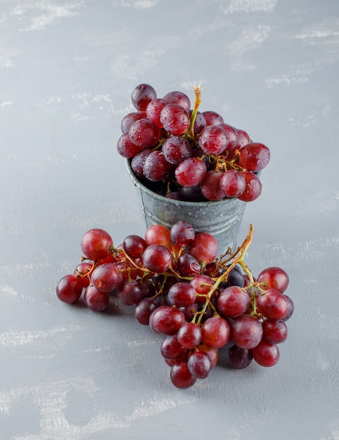 Red grapes in a mini bucket on a plaster. high angle view.