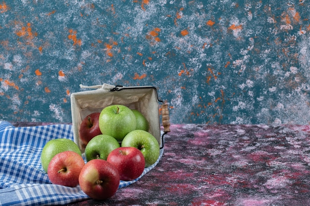 Free Photo red and green apples in a rustic basket