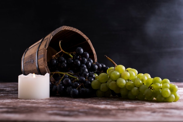 Red and green grape bunches out of a wooden bucket