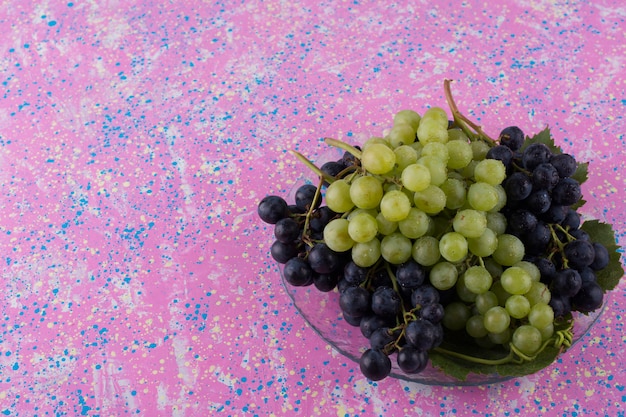 Free photo red and green grape bunches in a platter