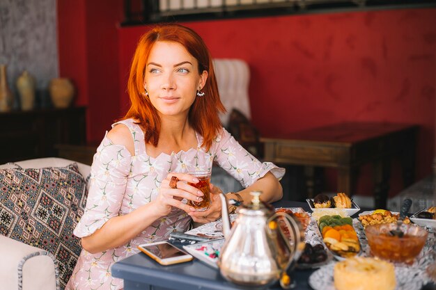 Red haired woman drinking tea at the restaurant