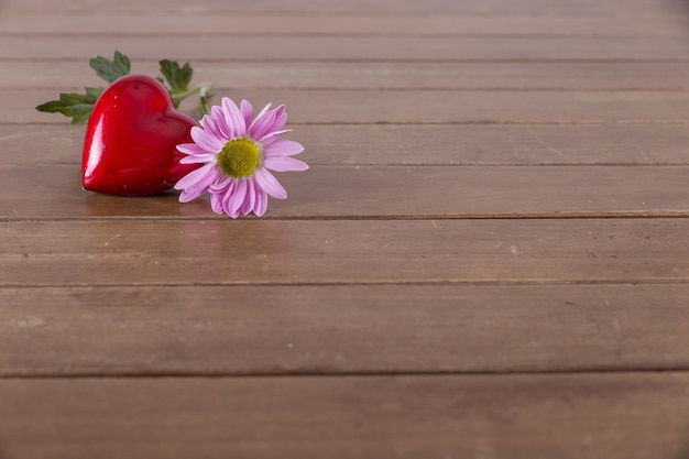 Free photo red heart and flower on a table